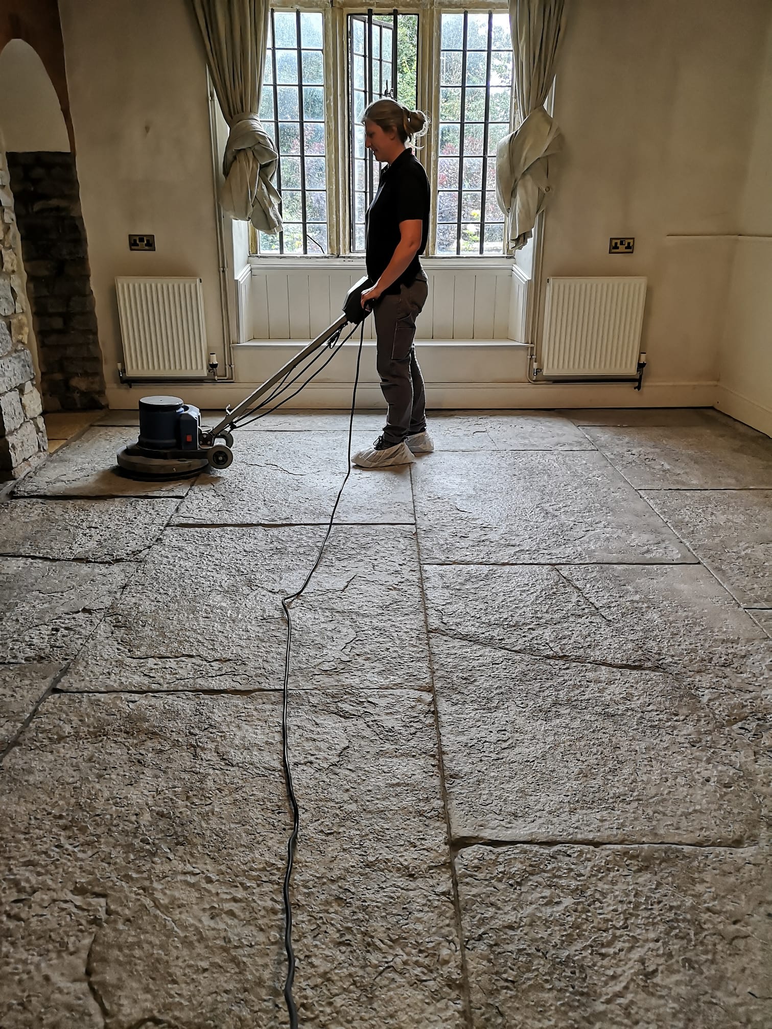 Freshly restored flagstone floor being swept with a soft broom