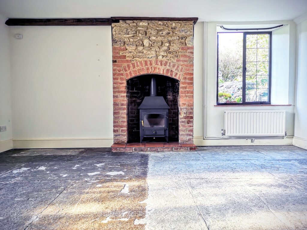 Flagstone floor during restoration showing before and after contrast