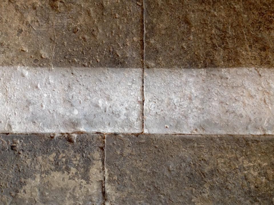 Flagstone floor showing partial cleaning and stripping process during restoration